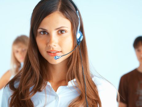 Young beautiful woman with headset with some people at the background
