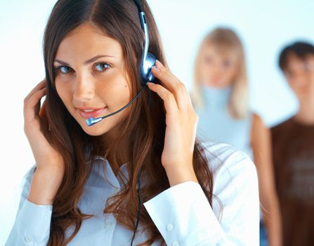 Young beautiful woman with headset with some people at the background
