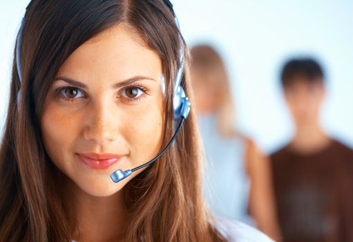 Young beautiful woman with headset with some people at the background
