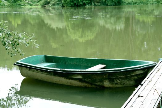 abandoned green boat at the river, peacefull landscape.