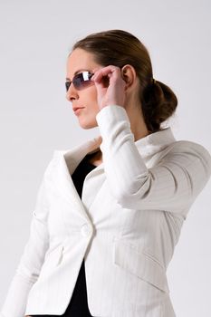 Young sturdy woman with sunglasses on a white background