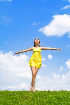 A beautiful girl on yellow dress and with red hair enjoying summer