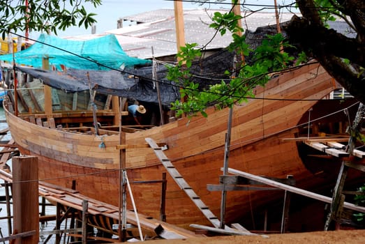 Building a wooden boat at a dry dock