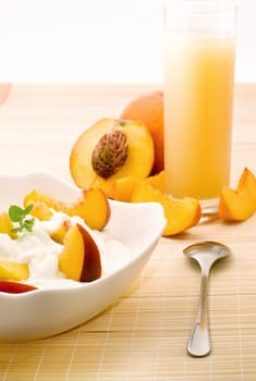 Yogurt with fresh peaches and mint for healthy breakfast. Light toning.