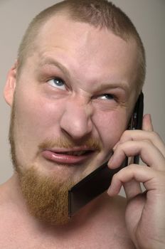 Young man talk to phone with screwed face