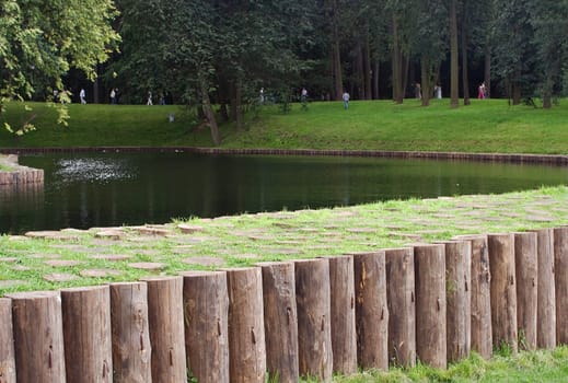 A row of wooden stumps (a part of a dam) next to the pond in Tsaritsino park