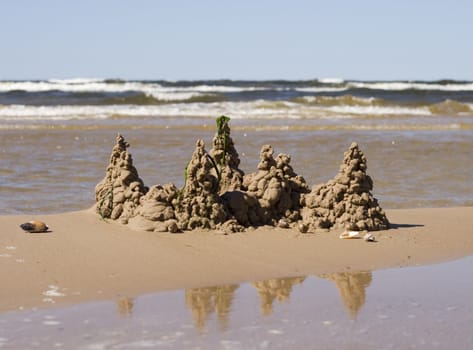 Sandcastle on a seaside with reflection