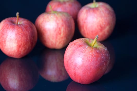 five, healthy red apples on black