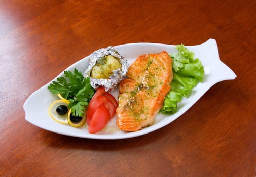 Stake from a salmon with vegetables on a plate. 