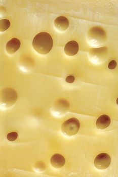 Background image of a large block of Swiss cheese (Emmentaler).
