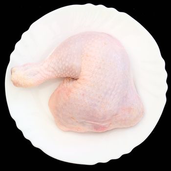 Raw chicken meat on a white plate on a black background