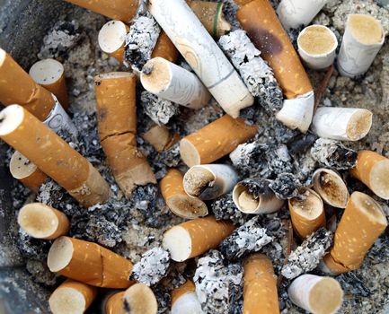Background Ashtray full of used Cigarette Butts  