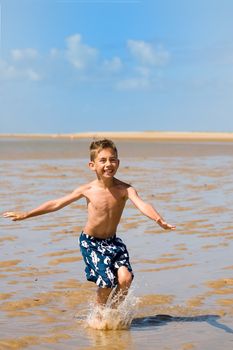 a boy landing on the beach after a high jump