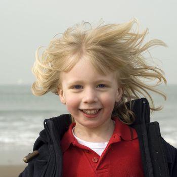 a young boy running on the beach