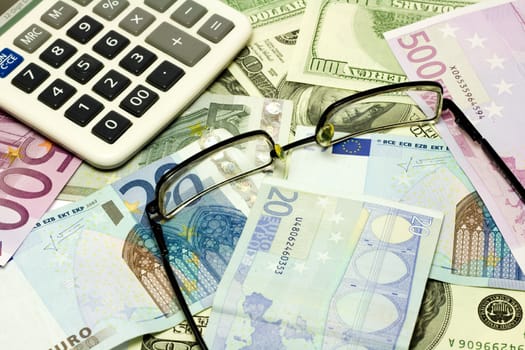 Dollar, euro banknotes, calculator, glasses
