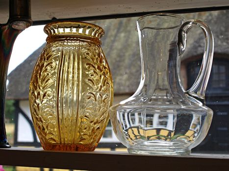Beautiful decorative glass carafes bottles display by the window       