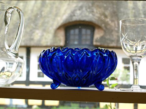 Beautiful decorative old blue glass bowl on display in a window   