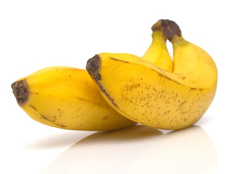 ripe bananas with real reflexion on white. Shallow DOF.