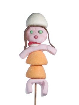 A female figurine made out of candies on a stick over a white background.