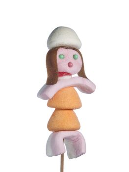 A female figurine made out of candies on a stick over a white background.