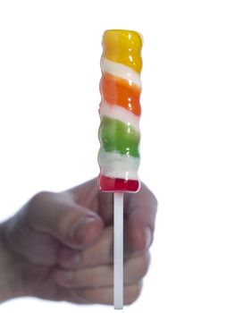 A hand out of focus about to grab a lollipop stick over a white background.