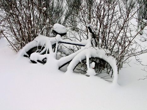 Bicycles covered with snow lay on the ground