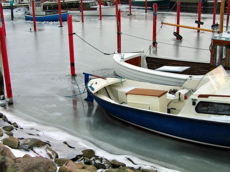 Boats anchored in a frozen marina in Fyn Denmark