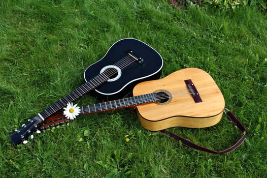 Two guitars on a green lawn after a concert