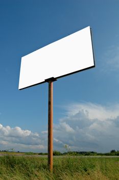 Empty publicity board on a background of a rural landscape and the sky with clouds