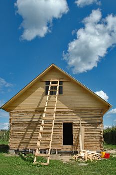 Building of a bathhouse from a bar on a country site against the sky with clouds