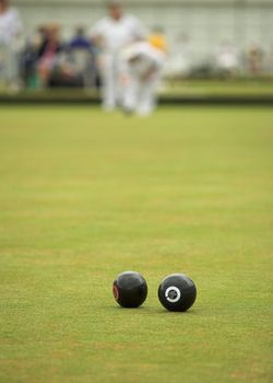A game of lawn bowls. Focus on the woods.
