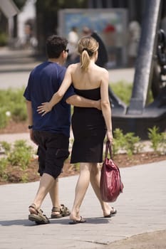 a couple walking on the street and holding each other