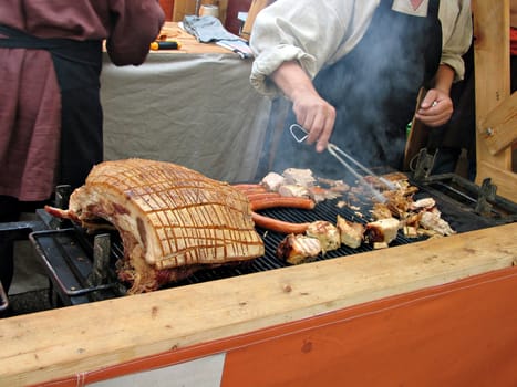 Meat being prepared on charcoal grill in Medieval style