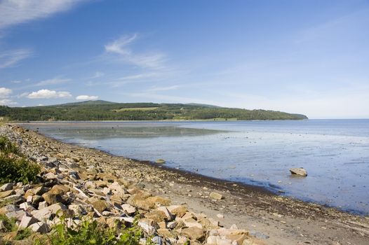 view of a rocky beach with mountains in the background