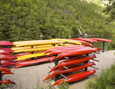 A bunch of yellow and red stacked kayaks