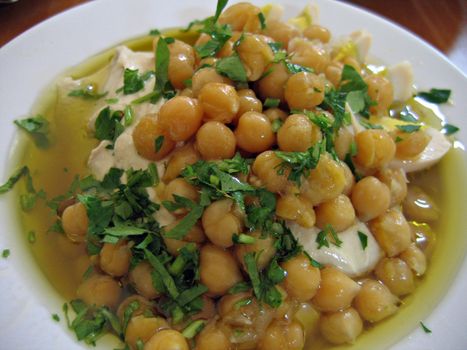 Dish of fresh Hummus with olive oil and parsley in close up - Middle East food