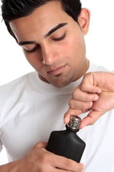 A man removes the lid from a bottle of aftershave cologne.