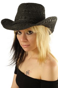 Image of a city girl with tattoo wearing a cowboy hat.
