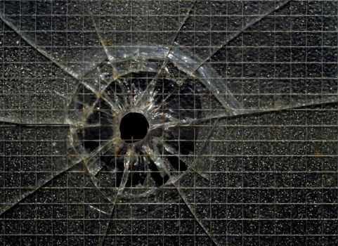 A bullet hole in industrial security glass
