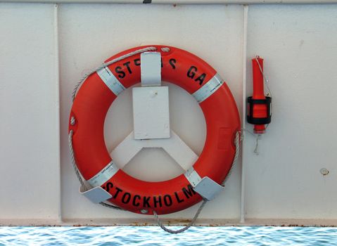 Lifering in bright orange color and safety light on a ship