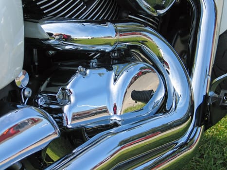 Details of motorcycle engine and exhaust in shiny chrome reflection