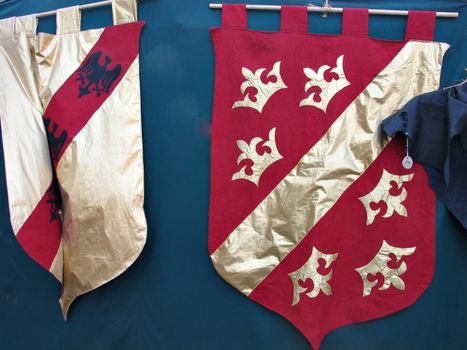 Medieval flags in red and gold hanged on a tent