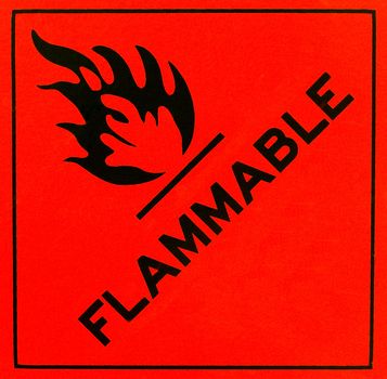 An orange flammable warning sign with black writing