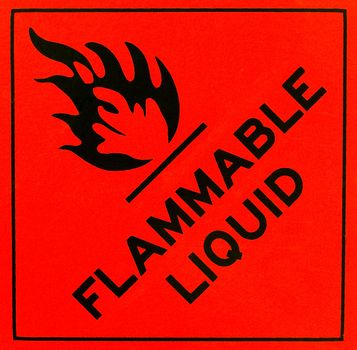 An orange flammable liquid warning sign with black writing