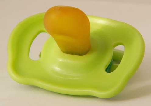green plastic dummy for a baby or child