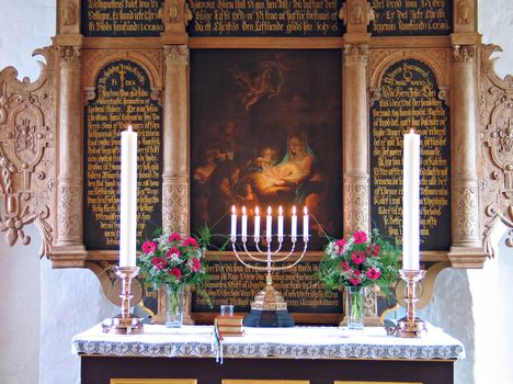 Alter in a church with candles and flowers during Baptismal ceremony