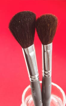 two large makeup brushes with grey and silver handles