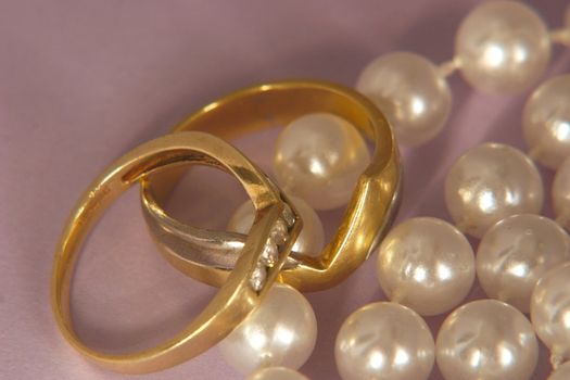two wedding rings and a string of pearls