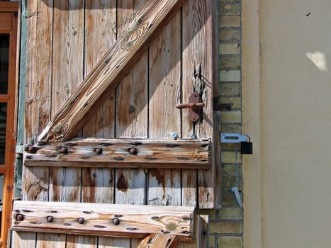 Details of an old rustic wooden door with heavy metal nails and lock