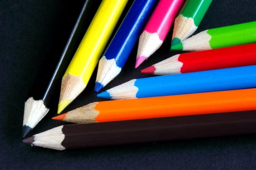 chevron of assorted coloured crayons against a dark background